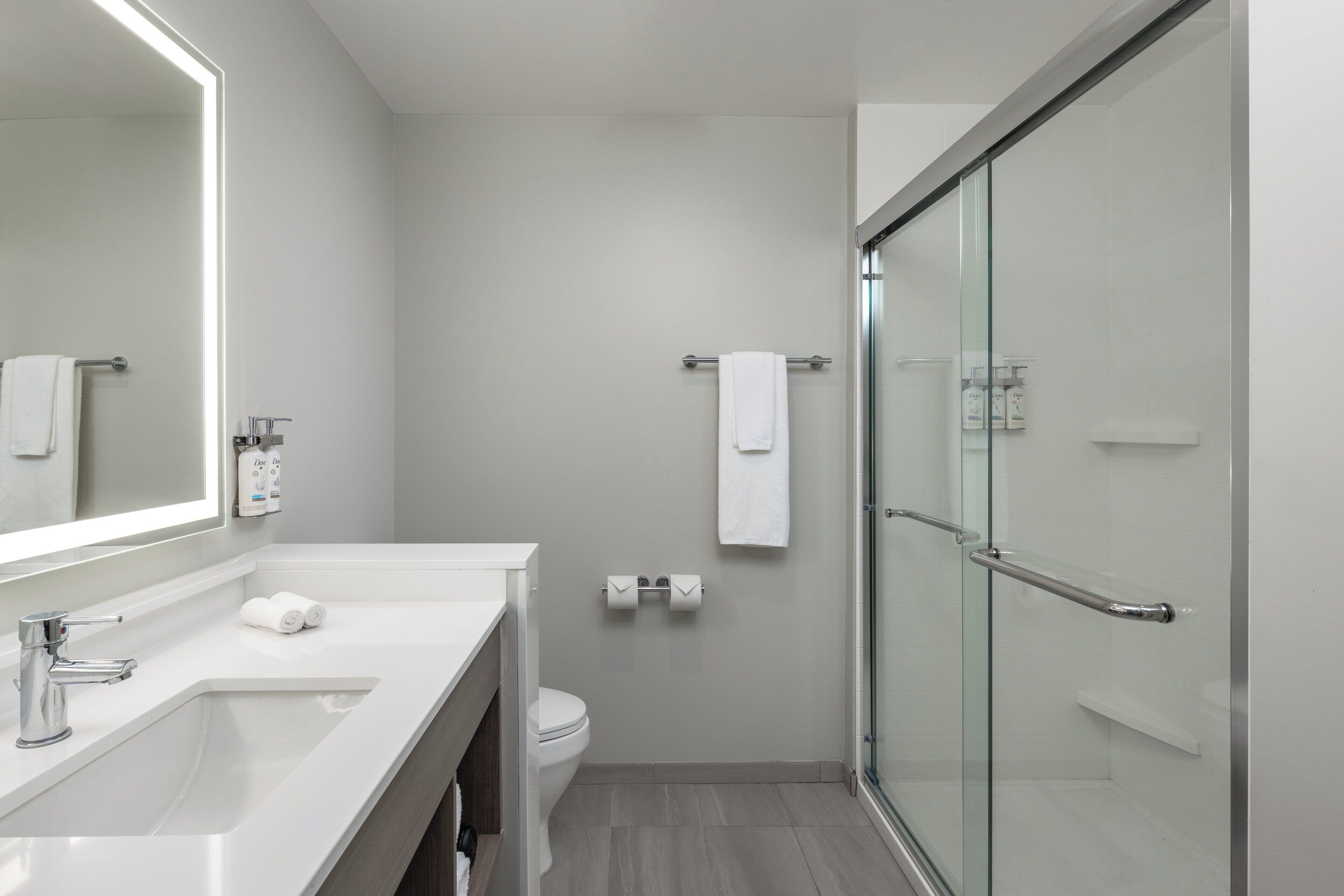 Une salle de bain moderne avec une douche à parois de verre, un lavabo blanc et des toilettes.