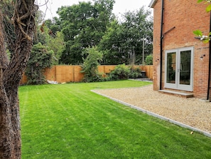 Enjoy a serene outdoor space with a beautifully manicured lawn and a path leading to a charming brick building.