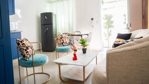 Un espacio habitable compacto con kitchenette, comedor y sofá.