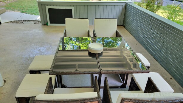 An outdoor patio with a glass-top table surrounded by wicker chairs and benches. - Bright, Modern Park Forest Home, 2.5m to Penn State! Breakfast included.  (State College)