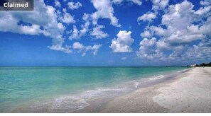 Enjoy a serene beach experience with clear turquoise waters and a sandy shore.