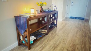 A wooden console table with a vase of yellow flowers, a lit candle holder, and a framed picture. - Modern 3 BD House in Cottonwood Downtown, 20 mins to Sedona.  (Cottonwood)