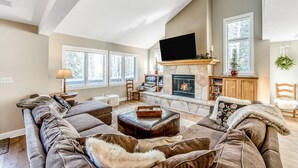 A spacious living room with a fireplace, comfortable seating, and large windows. - Private 5 Bedroom East Vail Getaway by Gorecreek Rentals (Vail)