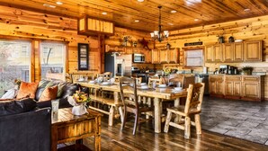 Un intérieur de cabine spacieux comprenant un coin repas en bois, un canapé et une cuisine avec des meubles et des appareils électroménagers en bois.