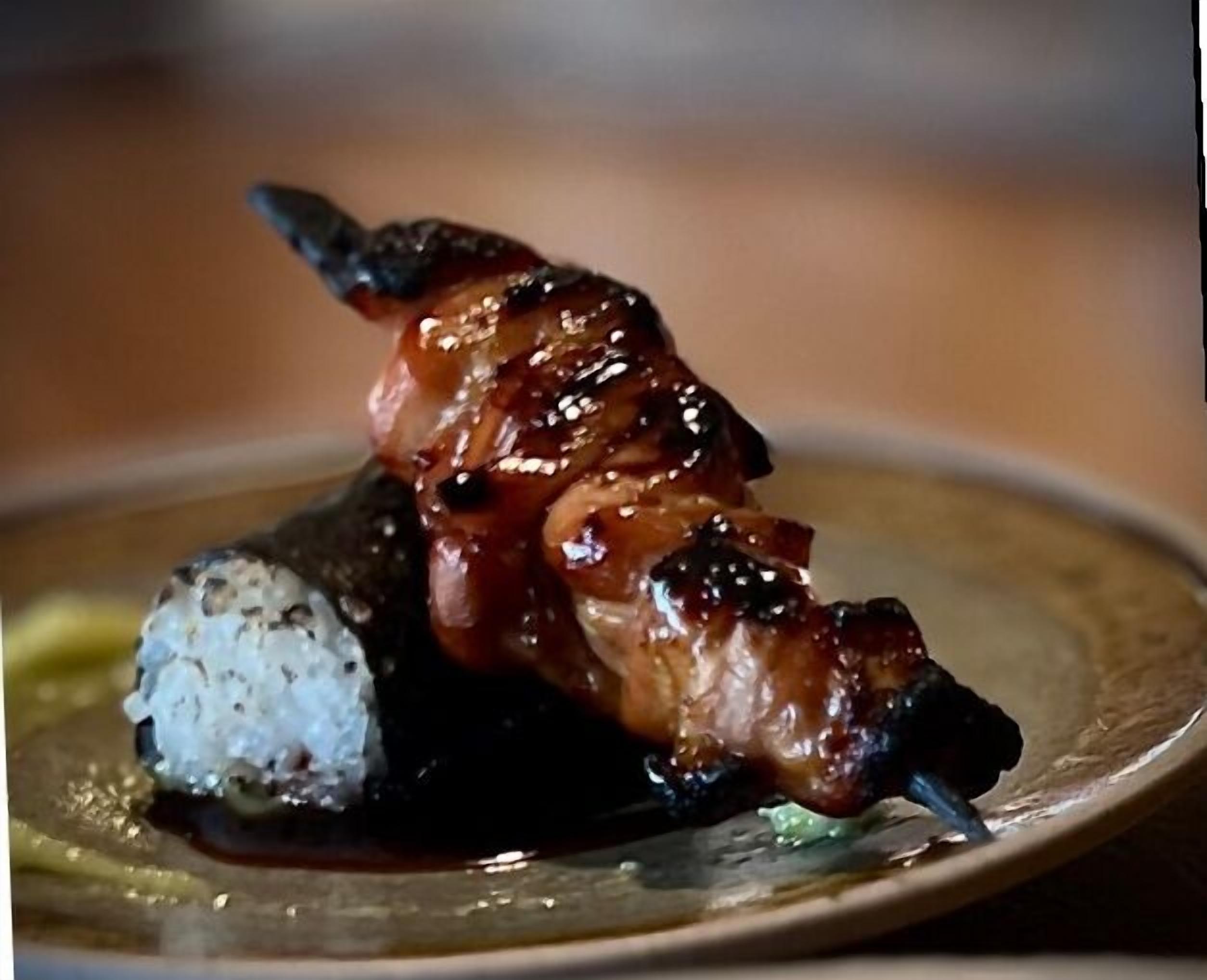 A dish with grilled meat and a mound of rice on a plate.