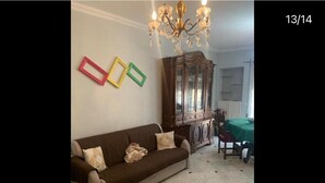 A living room with a sofa, a cabinet, and a chandelier. - Surrounded by greenery. Family-friendly apartment within walking distance of downtown (Roma)