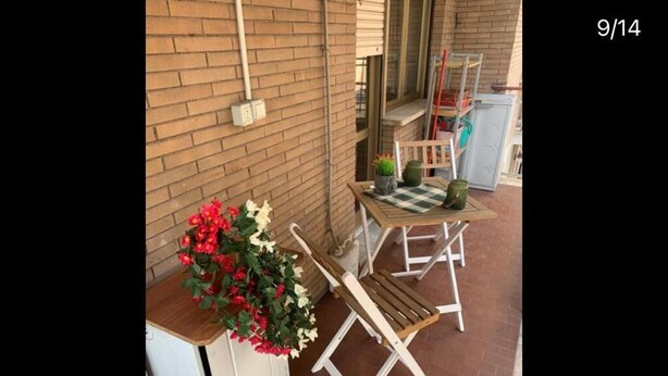 Un espace patio aménagé avec un banc en bois, une petite table et une plante en pot.