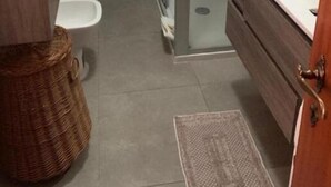 Une salle de bain avec une douche à parois de verre, des toilettes et un meuble-lavabo avec un évier.