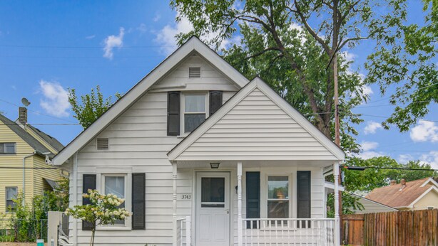 A two-story house with a front porch, a visible address number, and a fenced yard. - Cozy Chalet Bungalow in West Park - Cleveland (Cleveland)