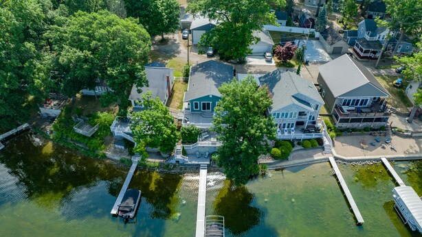 An aerial view of a residential area with houses, a dock, and a boat.