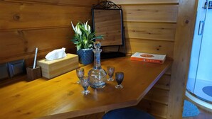L'intérieur d'un chalet en bois, avec une table en bois, une plante en pot, un livre et un miroir.