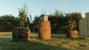 Three wooden planters with flowers in a grassy field. - Glamping in Wiltshire the Green Knoll is a charm (Chippenham)