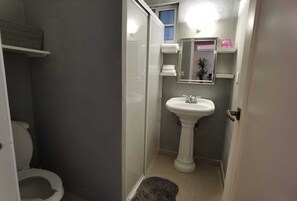 Ein kleines Badezimmer mit Toilette, Waschbecken und Spiegel.
