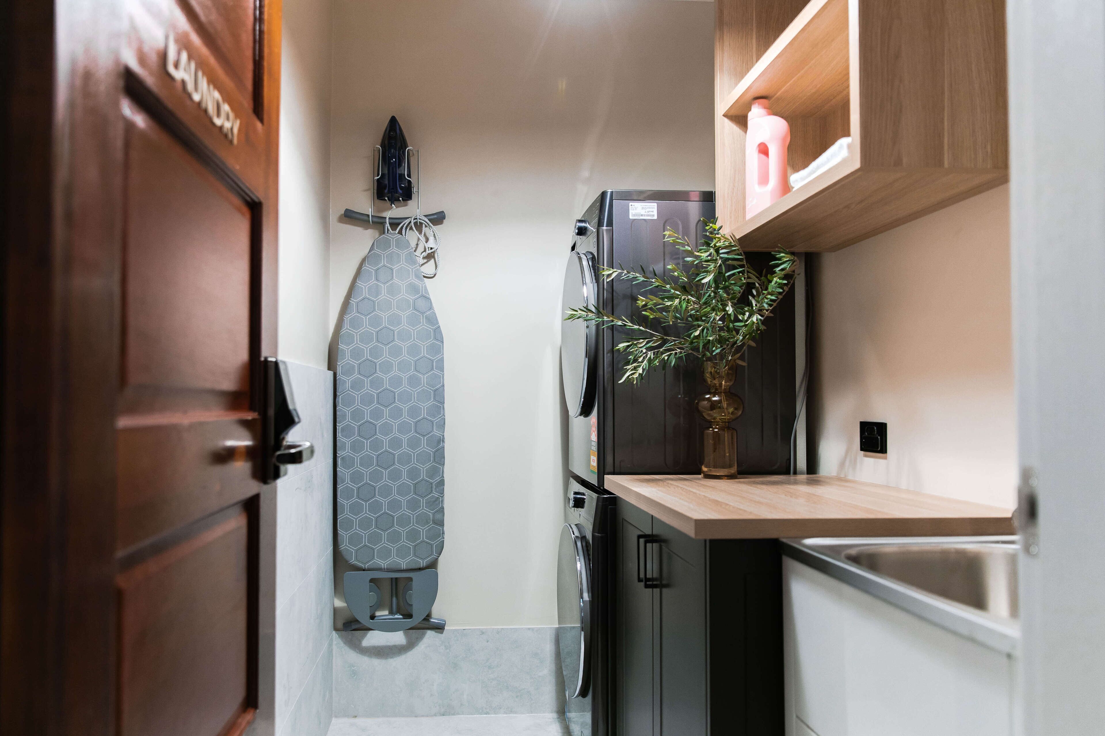 A compact kitchen with a built-in oven, a sink, and a countertop with a plant.