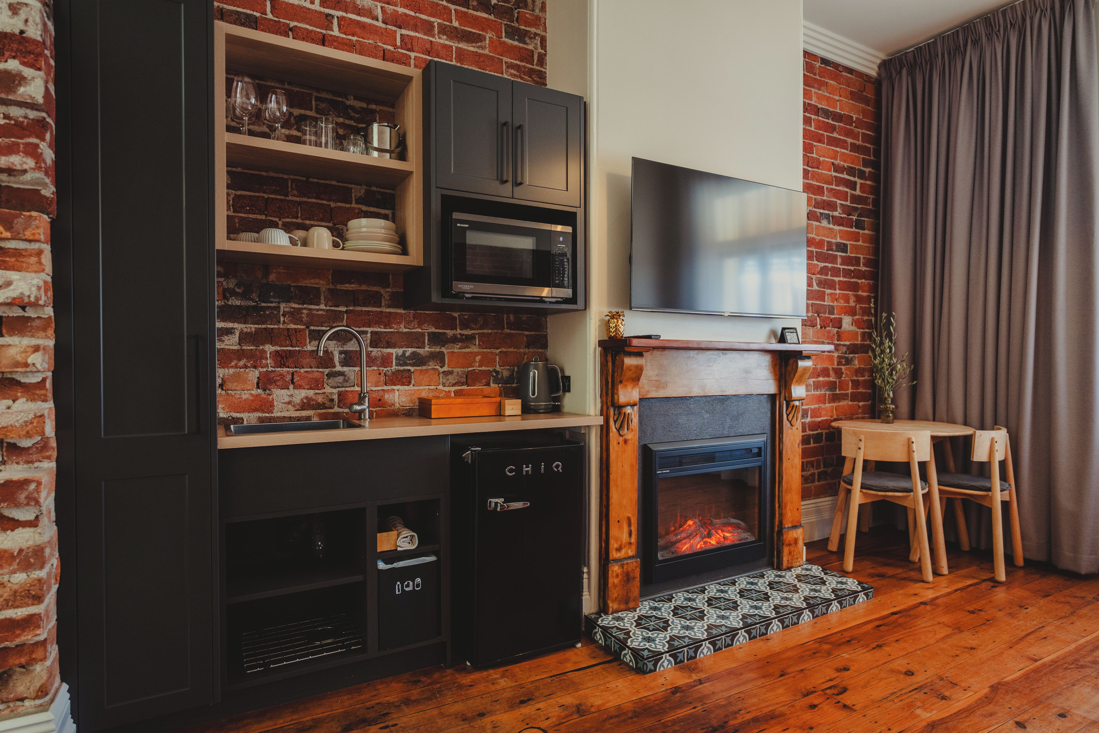 A compact kitchen with a built-in microwave, a dishwasher, and a small refrigerator.