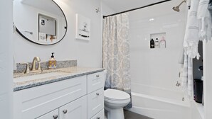 A modern bathroom with a white sink, a toilet, and a bathtub.