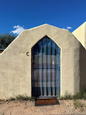Un edificio con una entrada de arco distintiva y la letra 'C' en la puerta.