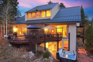 Een modern huis met een terras, buitenmeubilair en een jacuzzi.