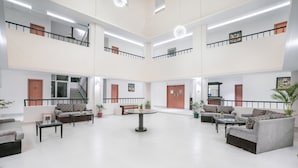 A spacious, multi-level lobby with modern furnishings, including sofas and a central table, and multiple doors leading to different areas. - Mithila Yatri Niwas (Janakpur)