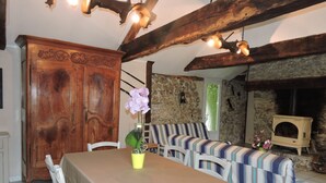 A dining area with a table, chairs, a bench, and a stone wall. - A miller's house in the quiet countryside for 2 people, pets welcome (Montredon-Labessonnié)