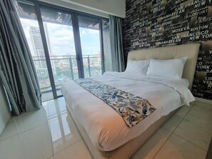 A hotel room with a large bed, a view of the city through floor-to-ceiling windows, and a wall with city names.