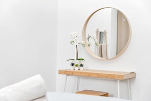 A minimalist vanity area with a round mirror, a wooden console table, and a small potted plant. - Belnem Breeze Kas Gosa with a private garden and a rinse tank for your dive gear (Kralendijk)