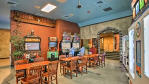 Ein Spielbereich mit Spielautomaten, Holztischen und Stühlen.