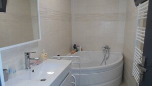 Ein Badezimmer mit Waschbecken, Spiegel und einer großen Badewanne.