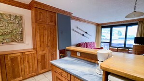 Eine Küche mit Holzschränken, einer Marmorarbeitsplatte, einem Spülbecken und einem Fenster mit Blick.