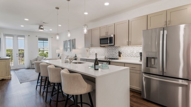 A modern kitchen with a central island, stainless steel appliances, and pendant lighting. - 30A Endless Summer by AvantStay | 1 Block to Beach | Pool + Tennis (Santa Rosa Beach)