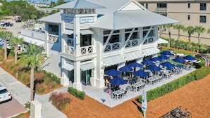 A coastal building with a balcony and outdoor seating area. - 30A Endless Summer by AvantStay | 1 Block to Beach | Pool + Tennis (Santa Rosa Beach)