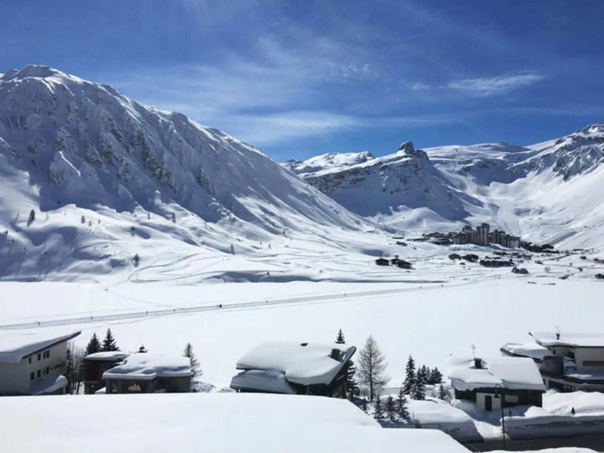 A snow-covered mountain landscape with buildings in the foreground.