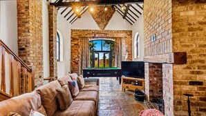 A cozy living room with a brick fireplace, a pool table, and a comfortable sofa. - Church Walk Farm (Snarestone)