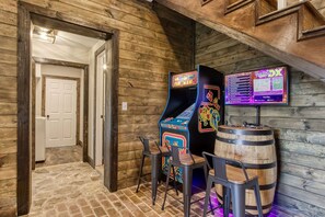 Un intérieur en bois avec des jeux d’arcade et des tabourets.