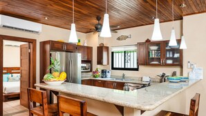 Une cuisine moderne dotée d’un îlot central, de meubles en bois et d’un grand réfrigérateur.
