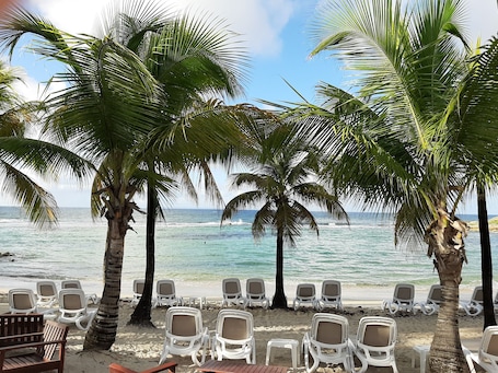 On the beach, white sand, sun loungers, beach umbrellas