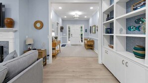 A hallway with a sofa, a table, and a bookshelf. - Luxury Retreat w/ Pool Near Beach on Hilton Head (Hilton Head Island)