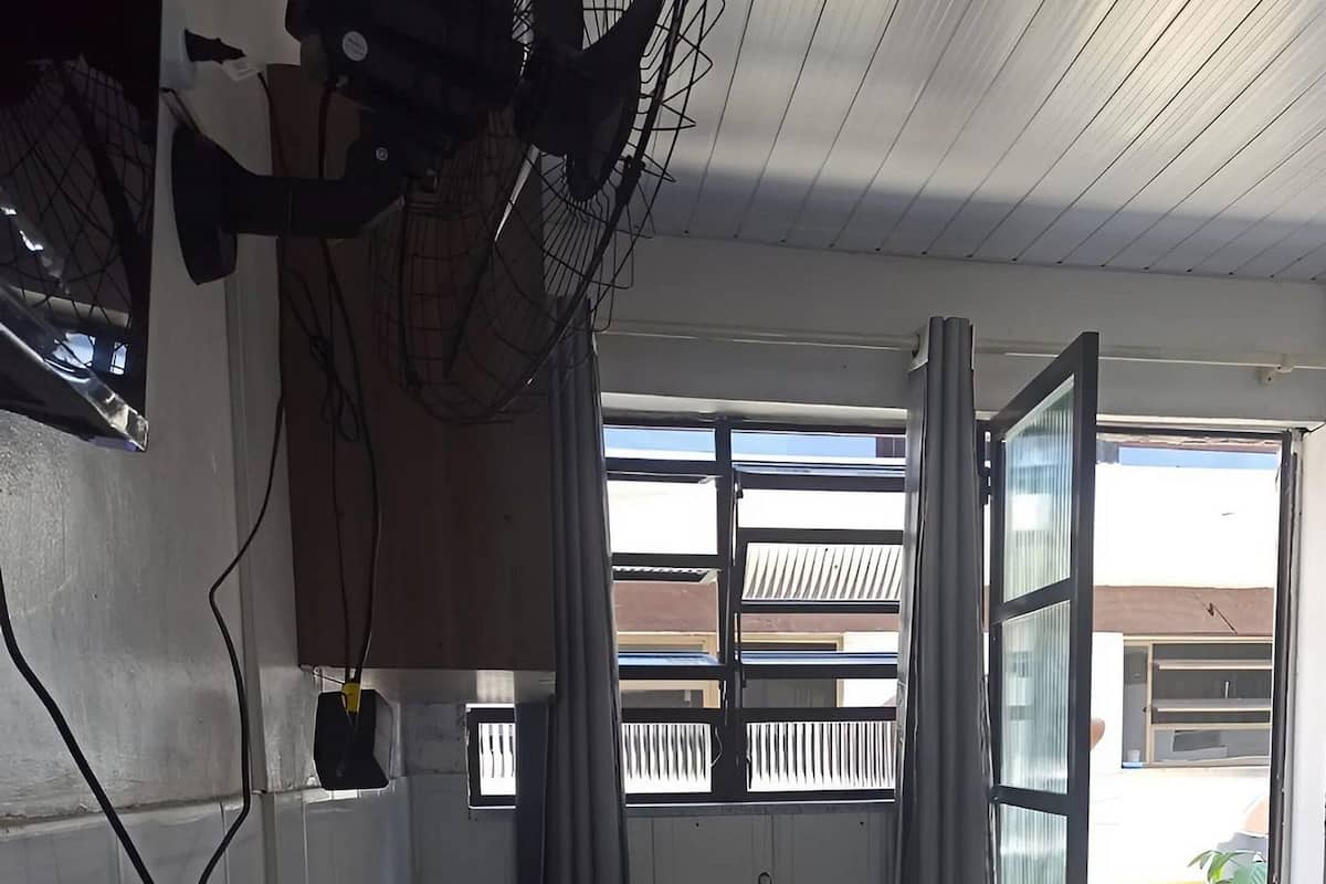 Une pièce dotée d’une grande fenêtre, d’une porte et d’un ventilateur de plafond.