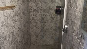 Ein Badezimmer mit Toilette, Waschbecken und Duschbereich.