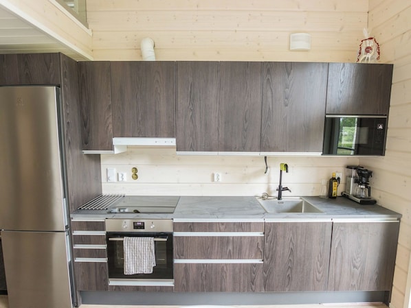 A modern kitchen with a stainless steel refrigerator, a microwave, and a built-in oven.