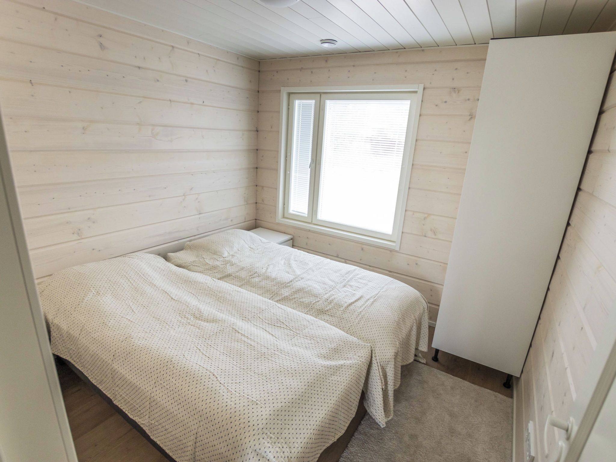 Une petite chambre avec un lit simple, une fenêtre et une armoire.