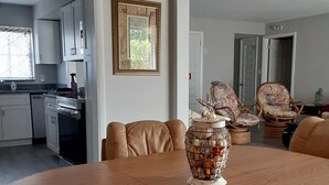 Un coin repas avec une table en bois, des chaises en cuir et un vase décoratif.