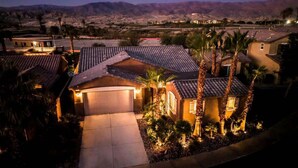 A residential area with houses, a driveway, and a mountain backdrop. - Polynesian Villa w/Private Pool & Tiki Bar Oasis (Indio)