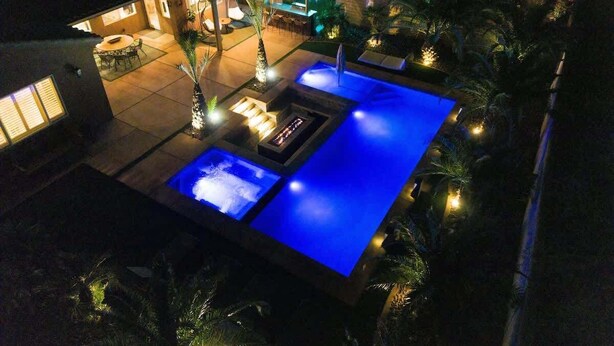 A pool area with multiple water features and lighting, surrounded by palm trees and a patio. - Polynesian Villa w/Private Pool & Tiki Bar Oasis (Indio)