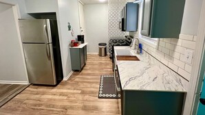 A compact kitchen with a stainless steel refrigerator, a microwave, and a sink. - 2 br home close to downtown and Lucas Oil. Pet Friendly! (Indianapolis)