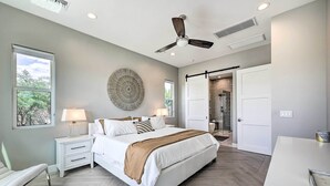 A modern bedroom with a large bed, bedside tables, a ceiling fan, and a walk-in closet. - Panoramic Mtn Views! Desert Home in Fountain Hills (Fountain Hills)