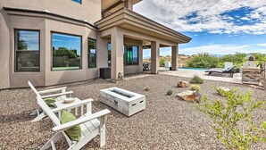 A modern house with a patio area featuring outdoor furniture and a fire pit. - Panoramic Mtn Views! Desert Home in Fountain Hills (Fountain Hills)