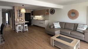 A modern apartment with a kitchen, dining area, and living room.