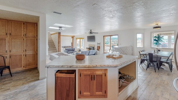 A spacious kitchen with wooden cabinets, a large island, and a dining area with a table and chairs.