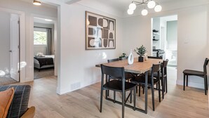 A modern interior with a dining area, a kitchen, and a bedroom.